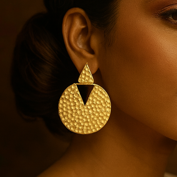 Woman wearing gold earrings with a warm brown background, featuring the brand 'ZOICRAFT'.
