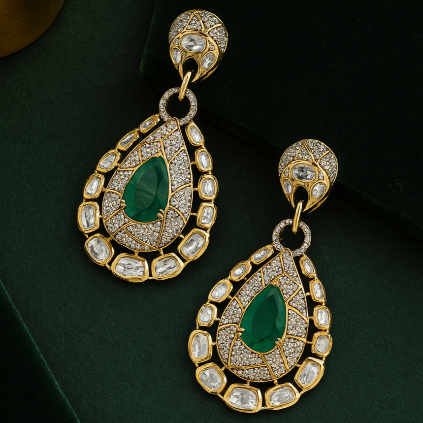 Pair of gold earrings with green gemstones on a dark background