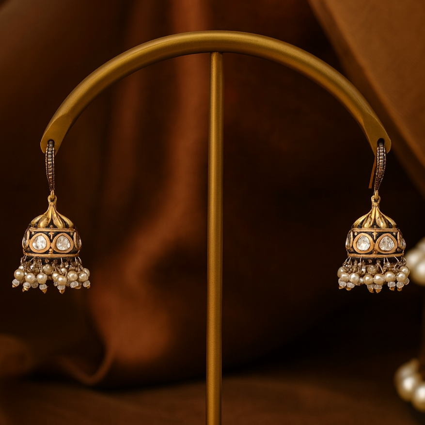 Pair of gold and pearl earrings on a brown background