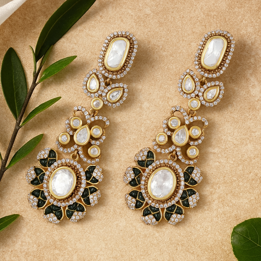 Ornate gold earrings with gemstones on a beige background with green leaves.
