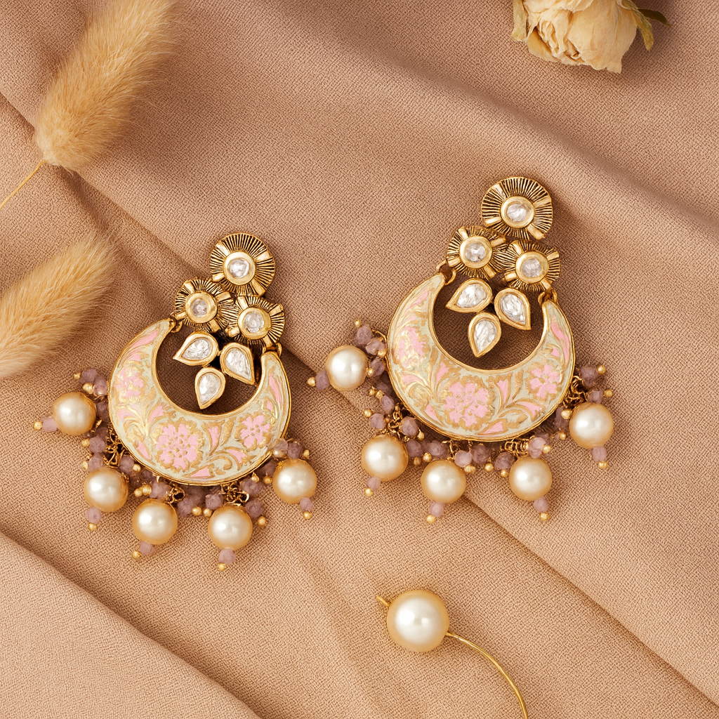 Decorative earrings with floral designs and pearls on a beige fabric background