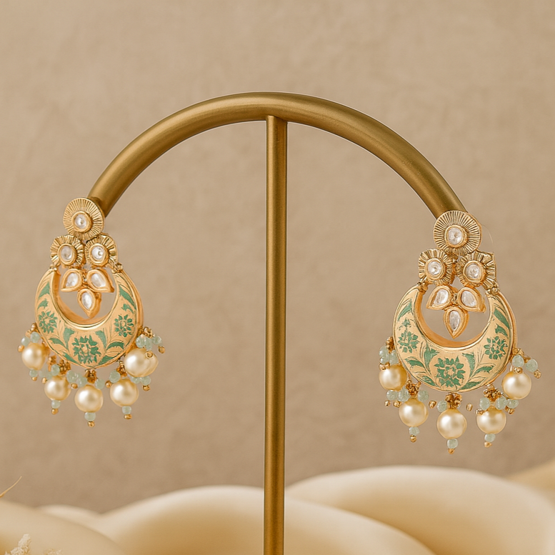 Ornate gold and pearl earrings on a beige stand with a soft beige background