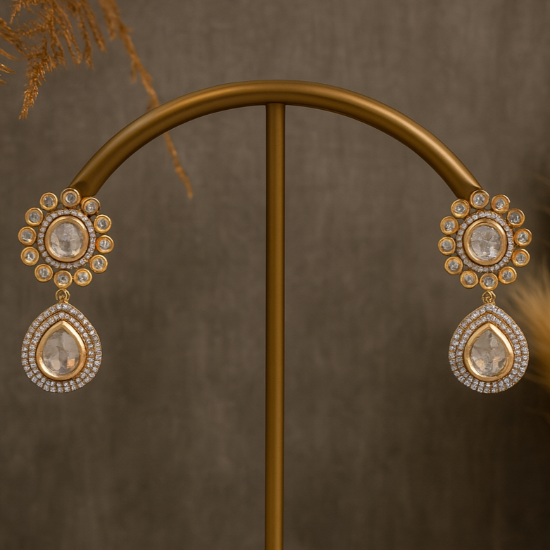 Pair of gold and diamond earrings on a stand with a brown background