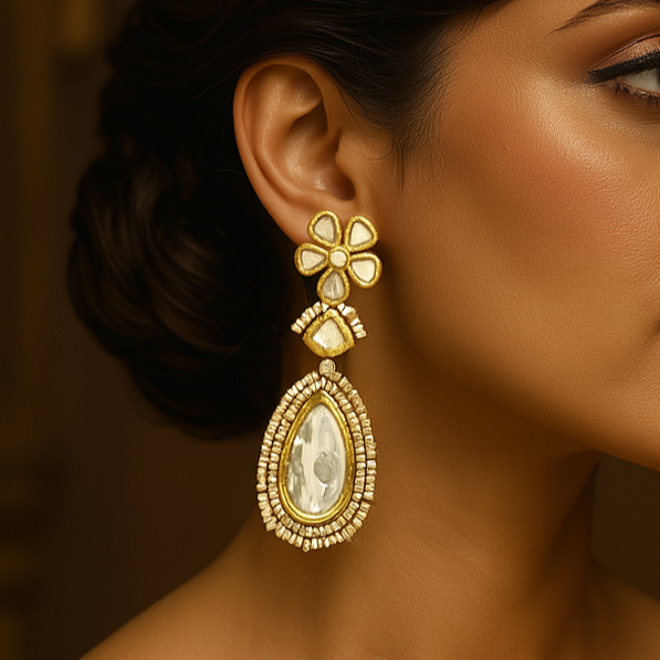Woman wearing gold earrings with a warm brown background