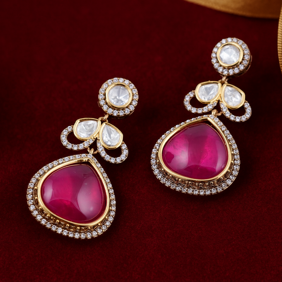 Gold earrings with red gemstones on a dark red background