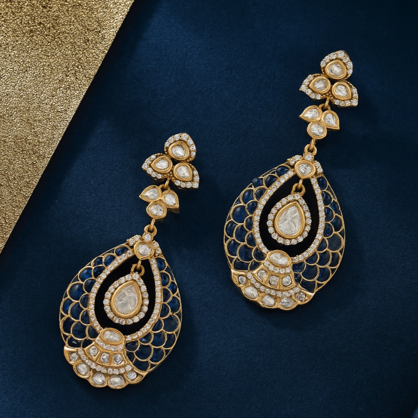 Ornate gold and black earrings on a dark blue background