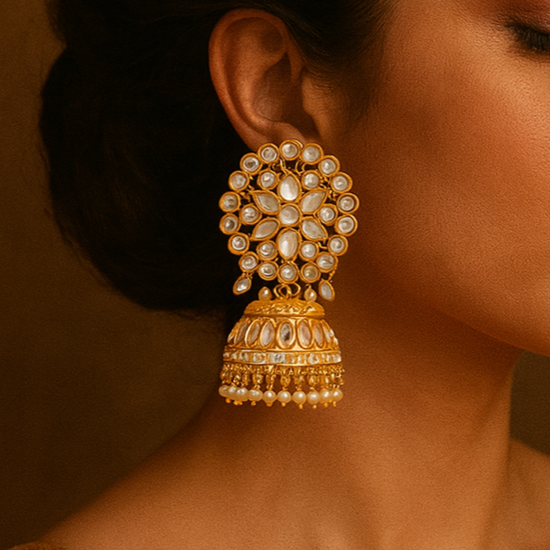 Woman wearing gold earrings with a warm brown background