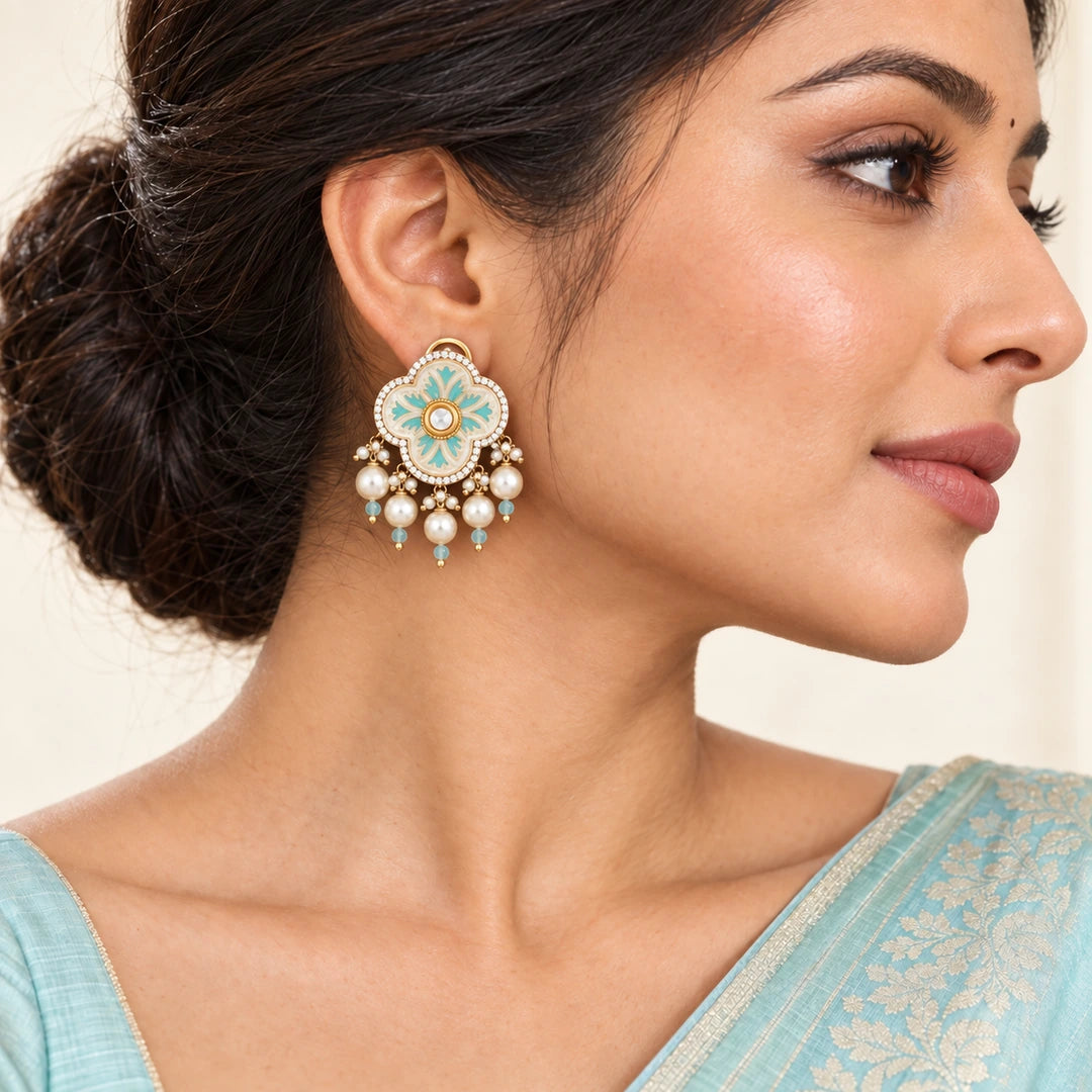 Indian model in an aqua saree wearing a Kairavi ivory floral earring with aqua detailing and five pearl-style drops.