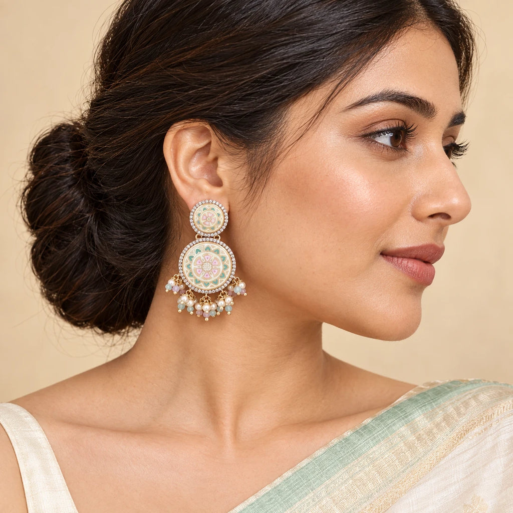 Indian model in an ivory saree with a mint border wearing a Kalika pastel floral drop earring with a pearl-style bead fringe.