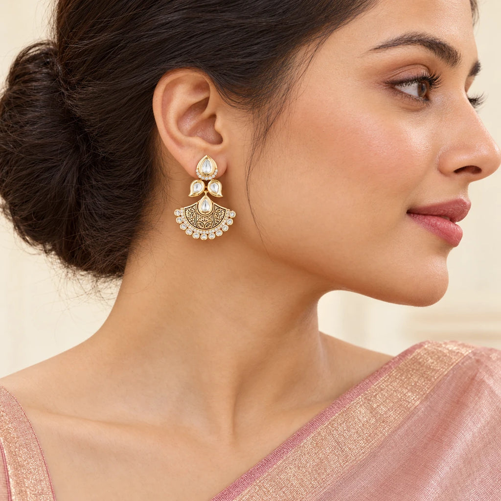 Indian model in a blush saree wearing a Kavya gold-tone floral chandbali earring, with hair swept back to reveal its clear stones and fan-shaped drop.