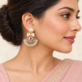 Indian model in a blush saree wearing a Kavya ruby-colour floral chandbali earring, with hair swept back.