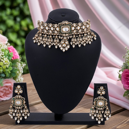 Ornate necklace and earrings set on a black stand with flowers in the background