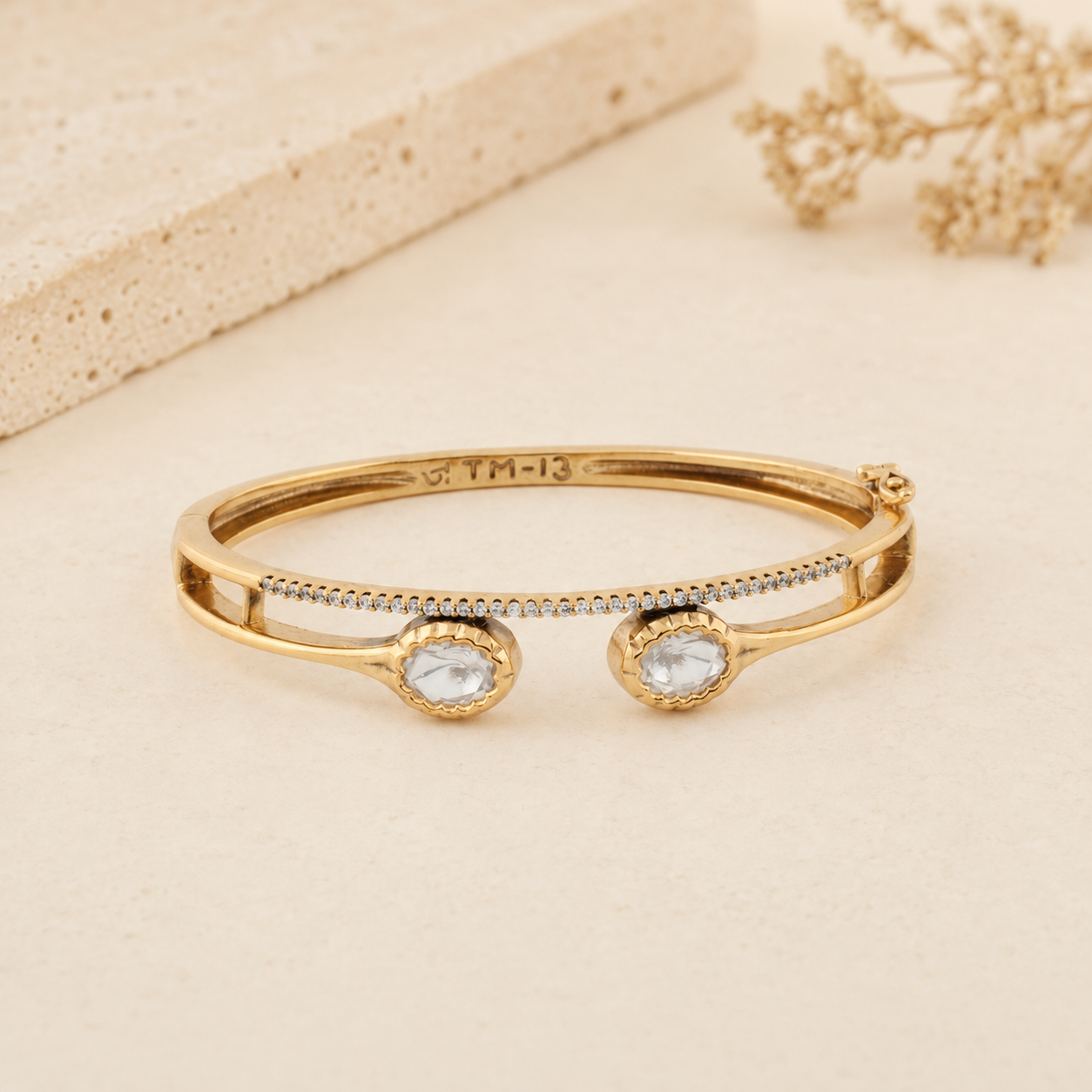 Aarika gold Polki-style twin-stone bracelet on a warm ivory luxury background