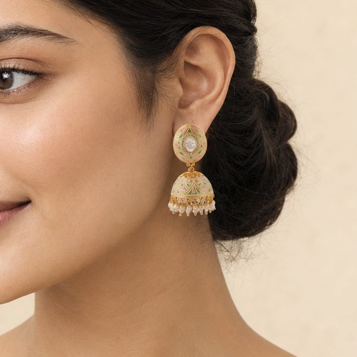 Indian model wearing Aarini pastel meenakari pearl jhumka earring in side profile