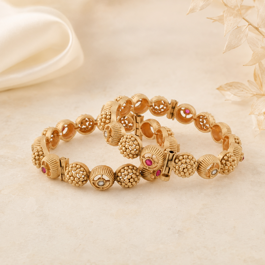 Aarohi antique gold textured bangle pair displayed on a warm ivory luxury background