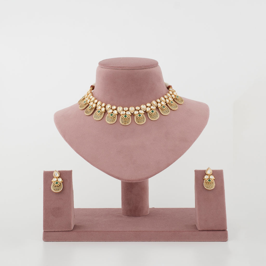 Aarunya antique gold artificial necklace set with diamond-look stones and emerald-green accents