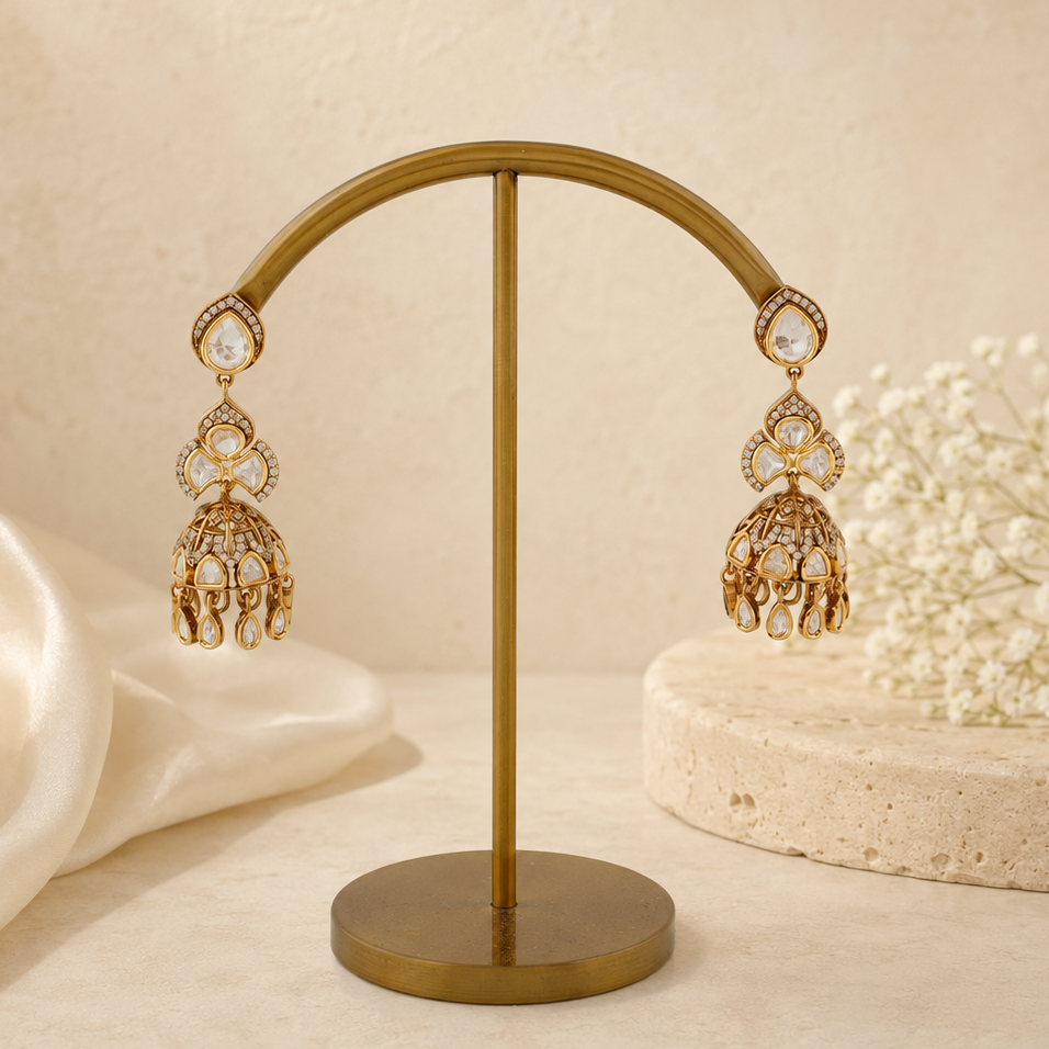 Aavya gold polki-look floral cage jhumka earrings styled on a luxury ivory background