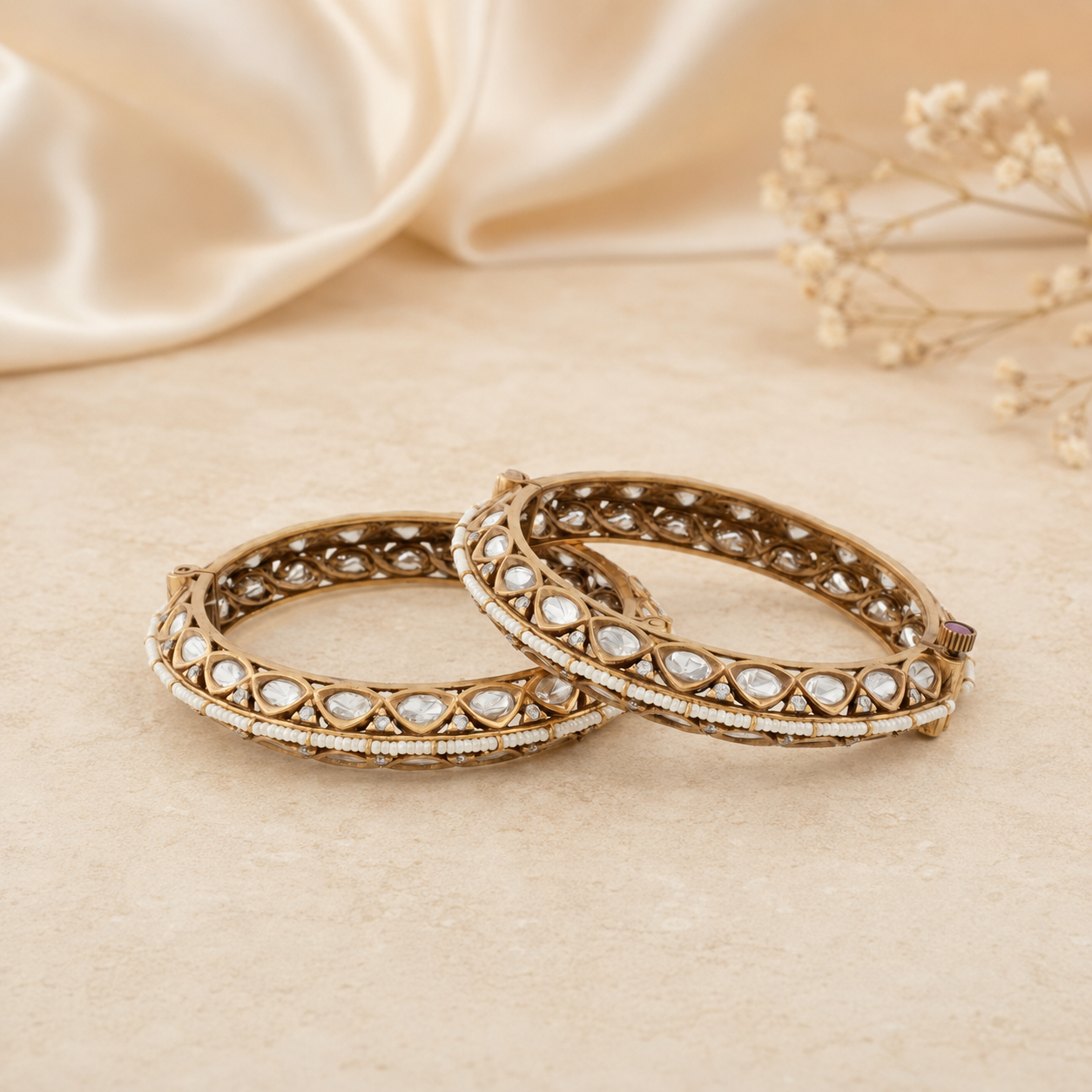 Avni antique gold Kundan bracelet pair displayed on a warm ivory