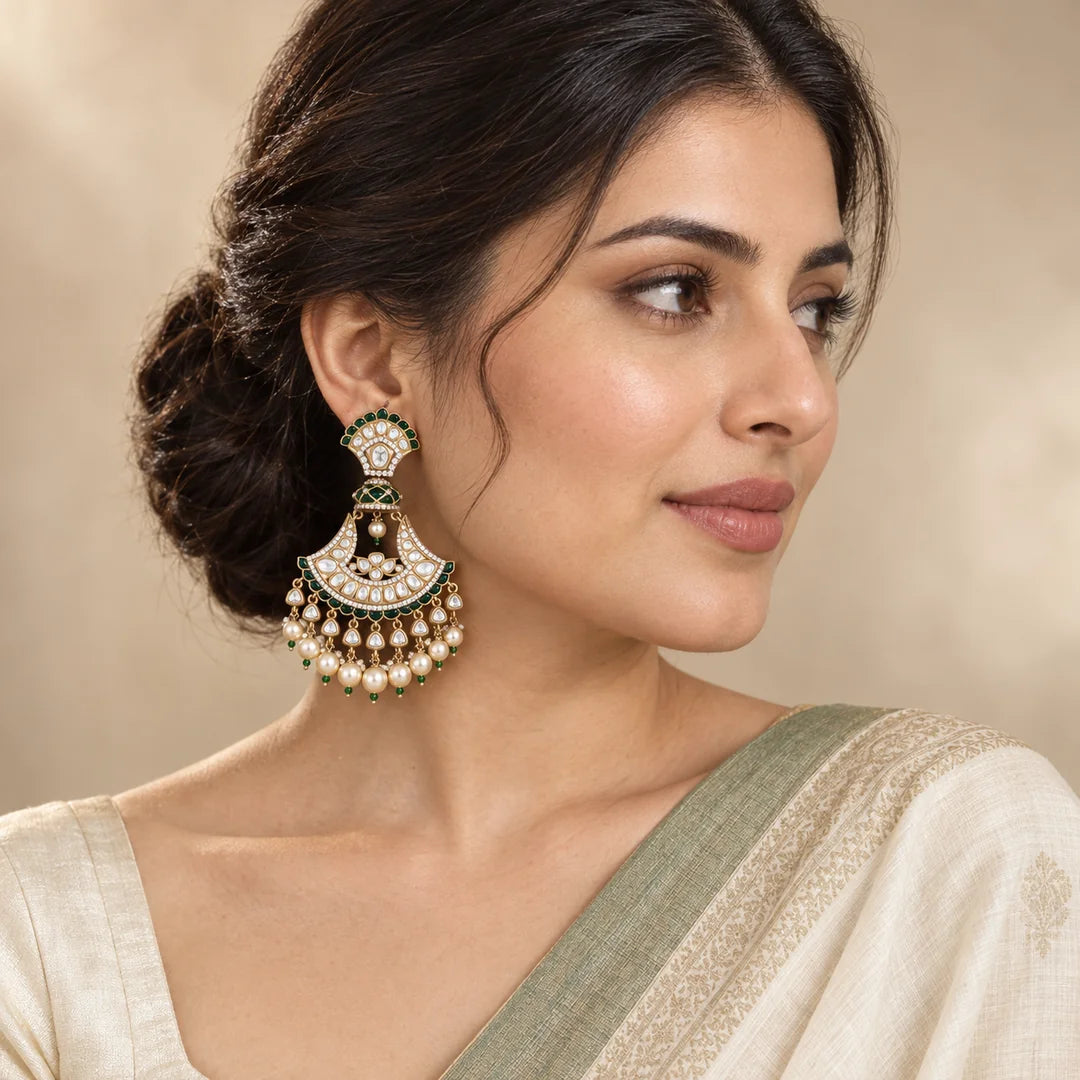 Indian model in an ivory saree with a sage border wearing a Chandrika green chandbali earring with pearl-look drops.