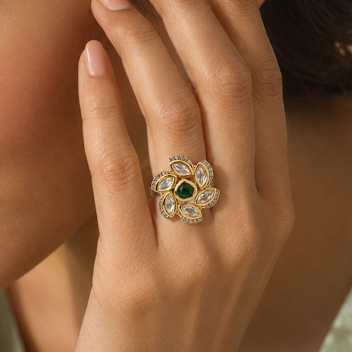 Woman wearing a gold-tone floral statement ring with a deep-green centre