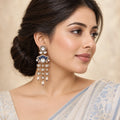 Indian model wearing a Gulika blue chandelier earring with clear stones and pearl-look drops, styled with a pale-blue and ivory saree.