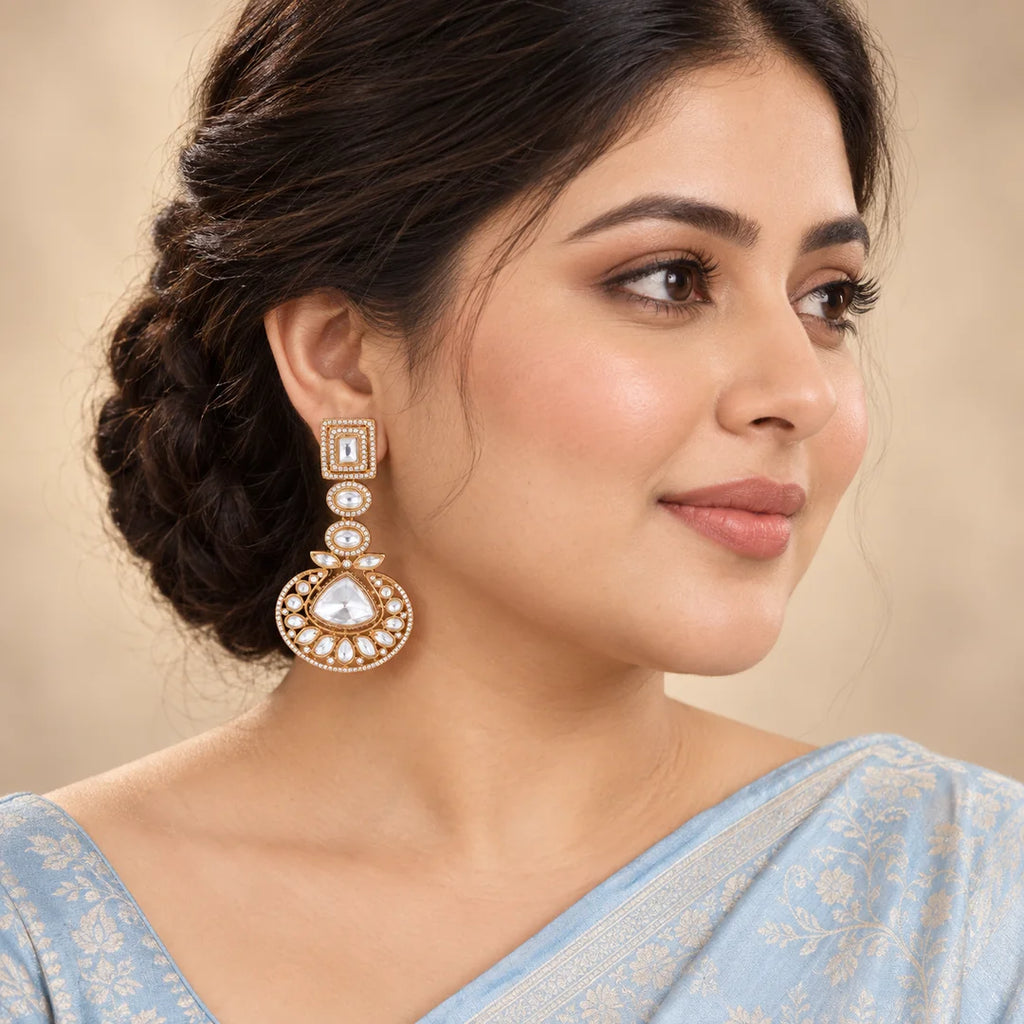 Indian model in a powder-blue saree wearing an Indira clear stone chandbali earring with a rectangular stud and crescent drop.