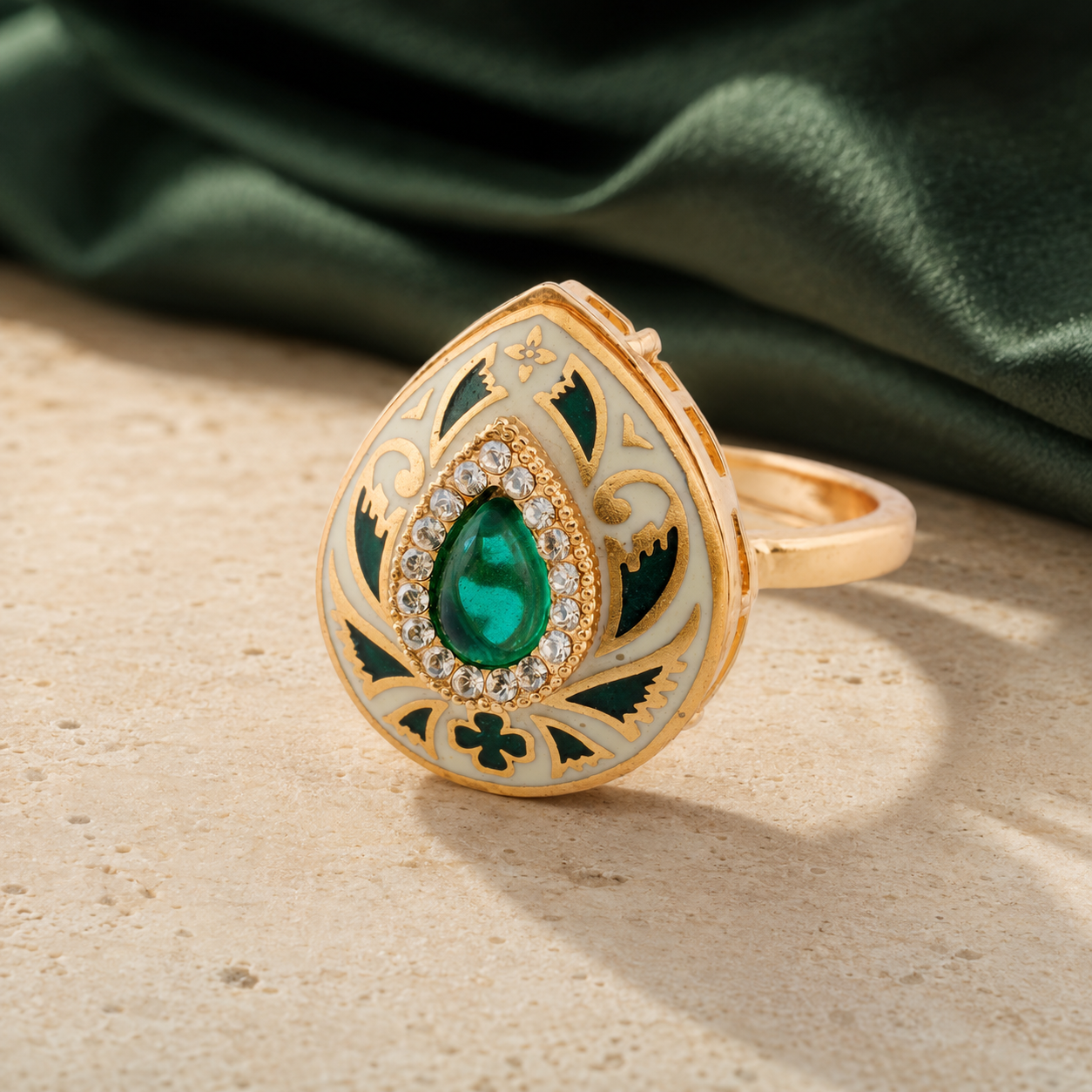 Green Meenakari teardrop statement ring displayed with deep-green fabric