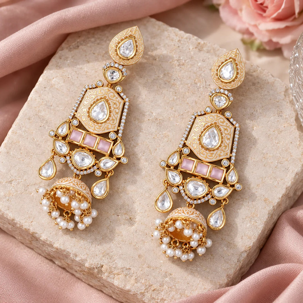 Pair of ivory and pink long jhumka earrings displayed on pale stone with blush silk and a pink rose.