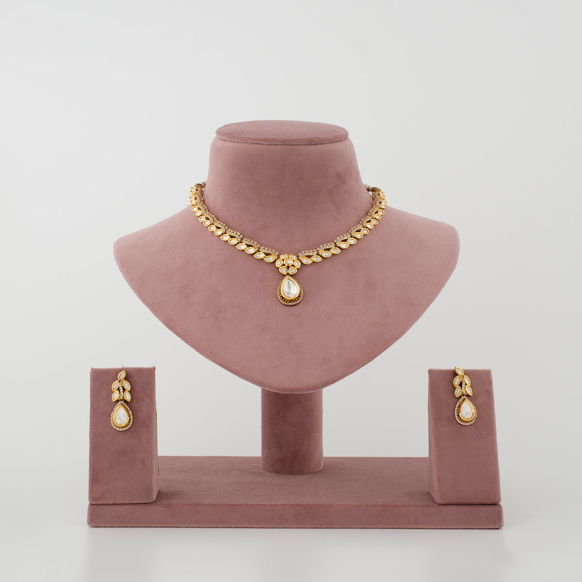 Ishvika gold-tone artificial necklace set with clear diamond-look stones and matching earrings