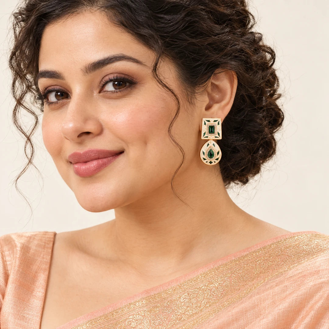 Indian model in a peach saree wearing a Kaashni ivory and green enamel-style drop earring, with her hair swept back.