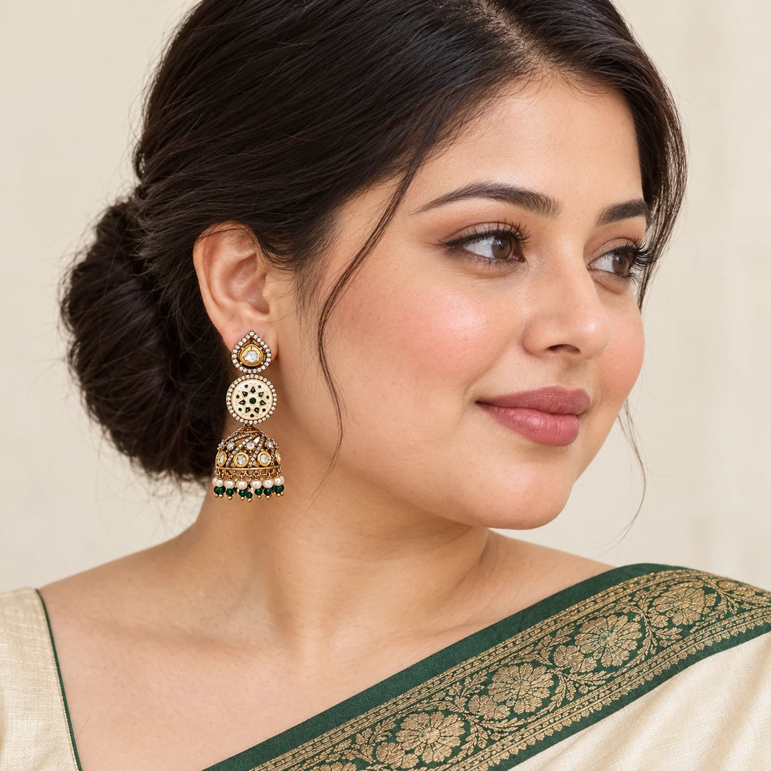 Indian model in an ivory saree with a forest-green border wearing a Kalika ivory and green floral jhumka with a pearl-style bead fringe.