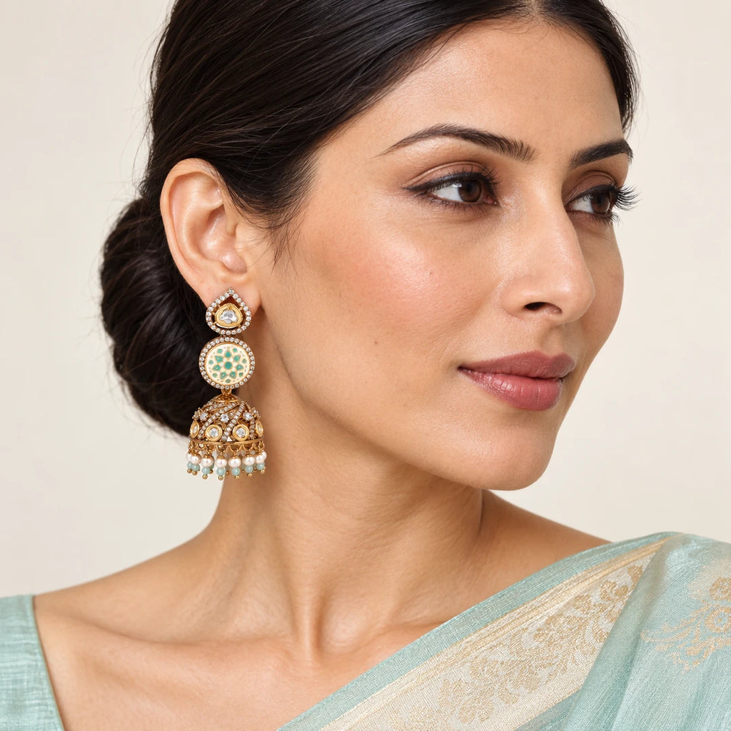 Indian model in a pale aqua saree wearing a Kalika ivory and mint floral jhumka with a stone-set dome and pearl-style bead fringe.
