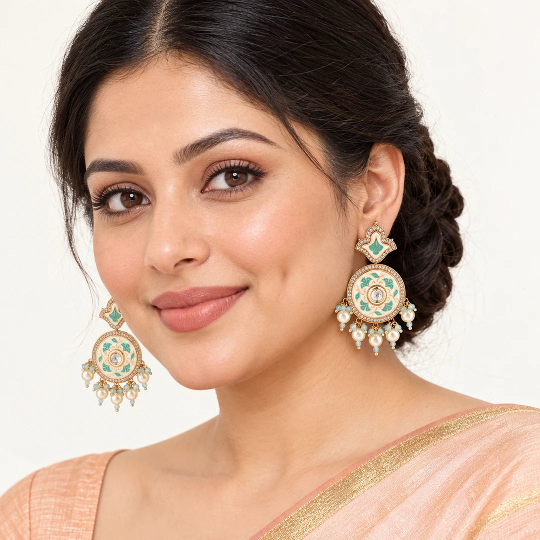 Indian model in a peach saree wearing Kalpita ivory and mint floral drop earrings with cream pearl-style fringe.