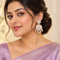 Indian model in a lavender saree wearing Kalpita ivory floral earrings with pink and mint details and cream pearl-style drops.