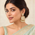 Indian model in a pale mint saree wearing a Kamini ivory drop earring with a clear-stone floral top, patterned panel and pearl-style fringe.