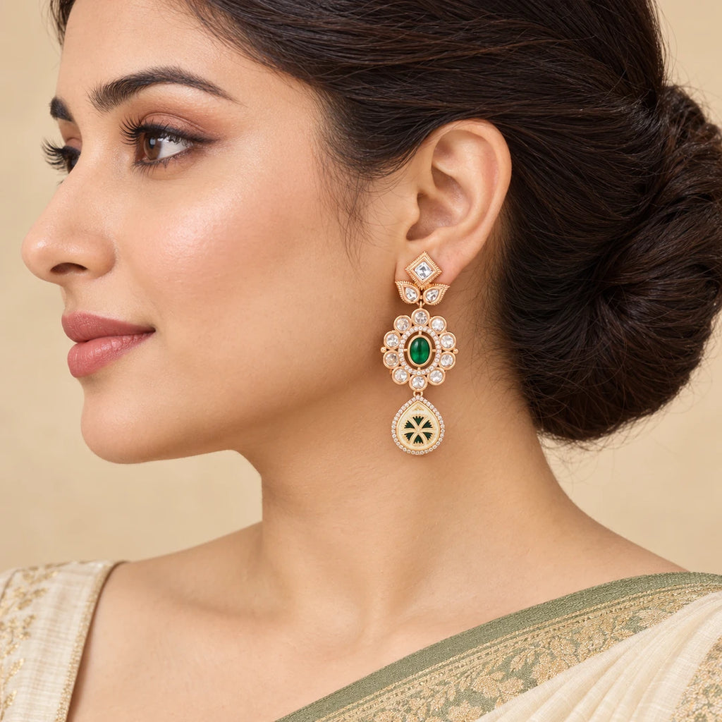 Model wearing a Kamya ivory and green floral drop earring with an ivory saree and sage border, hair swept into a bun.