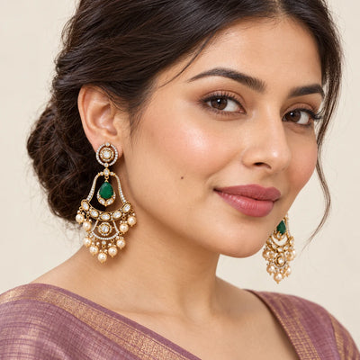Model in a mauve saree wearing Kanaklata green chandelier earrings with open gold-tone frames and cream pearl-style drops.