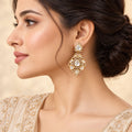 Side-profile model wearing one Kashvi gold-tone floral drop earring with pear-shaped clear stones and marquise accents.