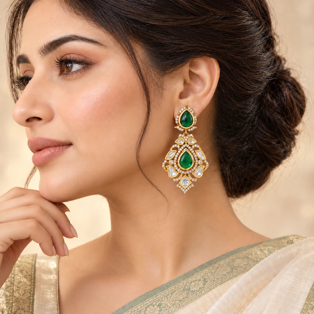 Indian model in an ivory saree with a sage border wearing a Kashvi green teardrop earring with clear stones.