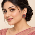 Indian model in a dusty rose saree wearing a Kavisha sage green and ruby-colour rectangular stud earring