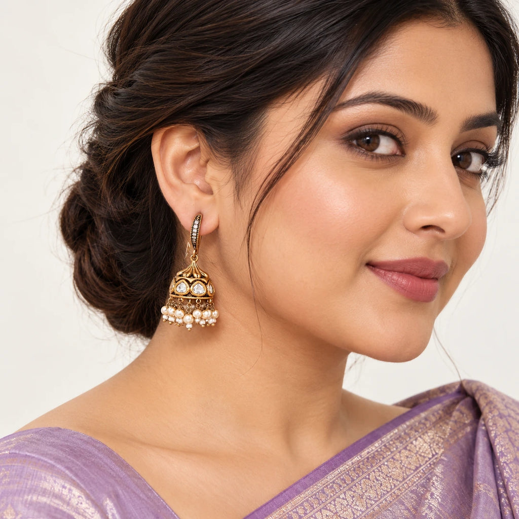 Model in a lavender silk saree wearing a Kavitha clear-stone hook jhumka with an antique-look gold-tone dome and cream pearl-style fringe.