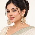 Model in an ivory saree with a sage border wearing Kesara ivory and mint peacock earrings with pearl-style drops.