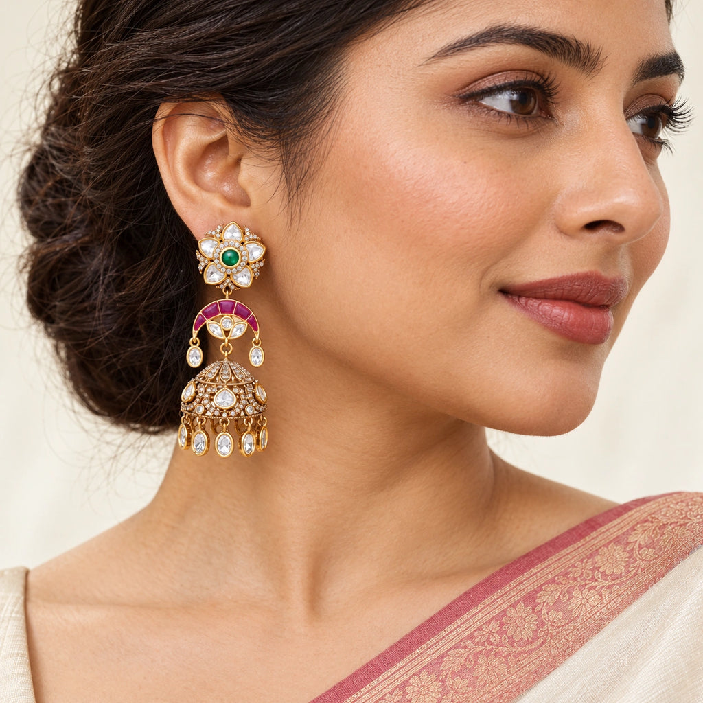 Indian model wearing Keshavi ruby-colour and green floral jhumka earrings with an ivory saree and rose border.