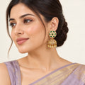 Indian model in a lavender saree wearing a Kiranya green floral jhumka earring with a pearl-style stud border and clear teardrop fringe.