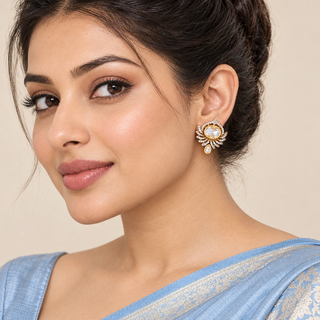 Indian model in a powder blue saree wearing a Koshika clear fan-style earring with an oval centre and small teardrop accent.