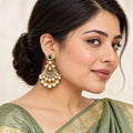 Indian model in a sage-green saree wearing a Kumudini chandbali earring with a green teardrop stud, engraved crescent and cream pearl-style drops.