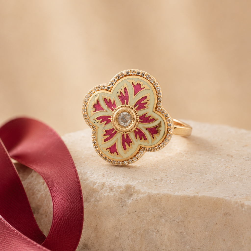 Gold-finish floral cocktail ring displayed on a neutral pedesta