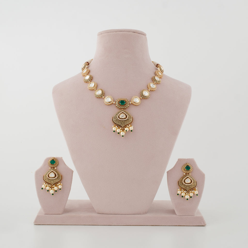 Meherika antique gold artificial necklace set with emerald stones, diamond-look details and matching earrings