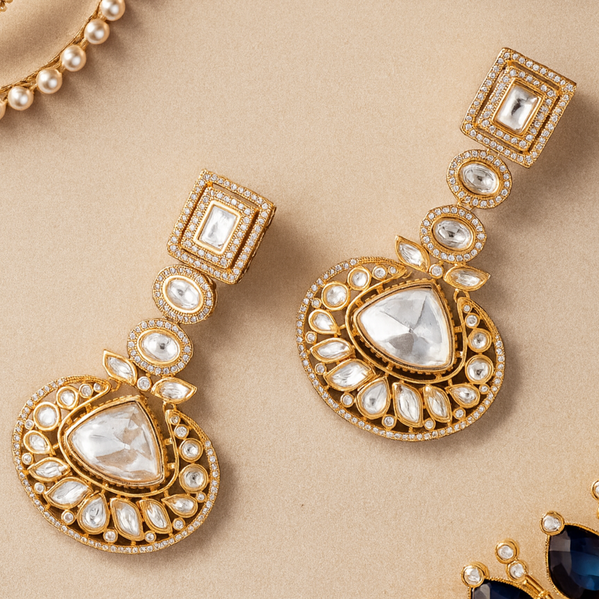 Gold earrings with gemstones on a beige background