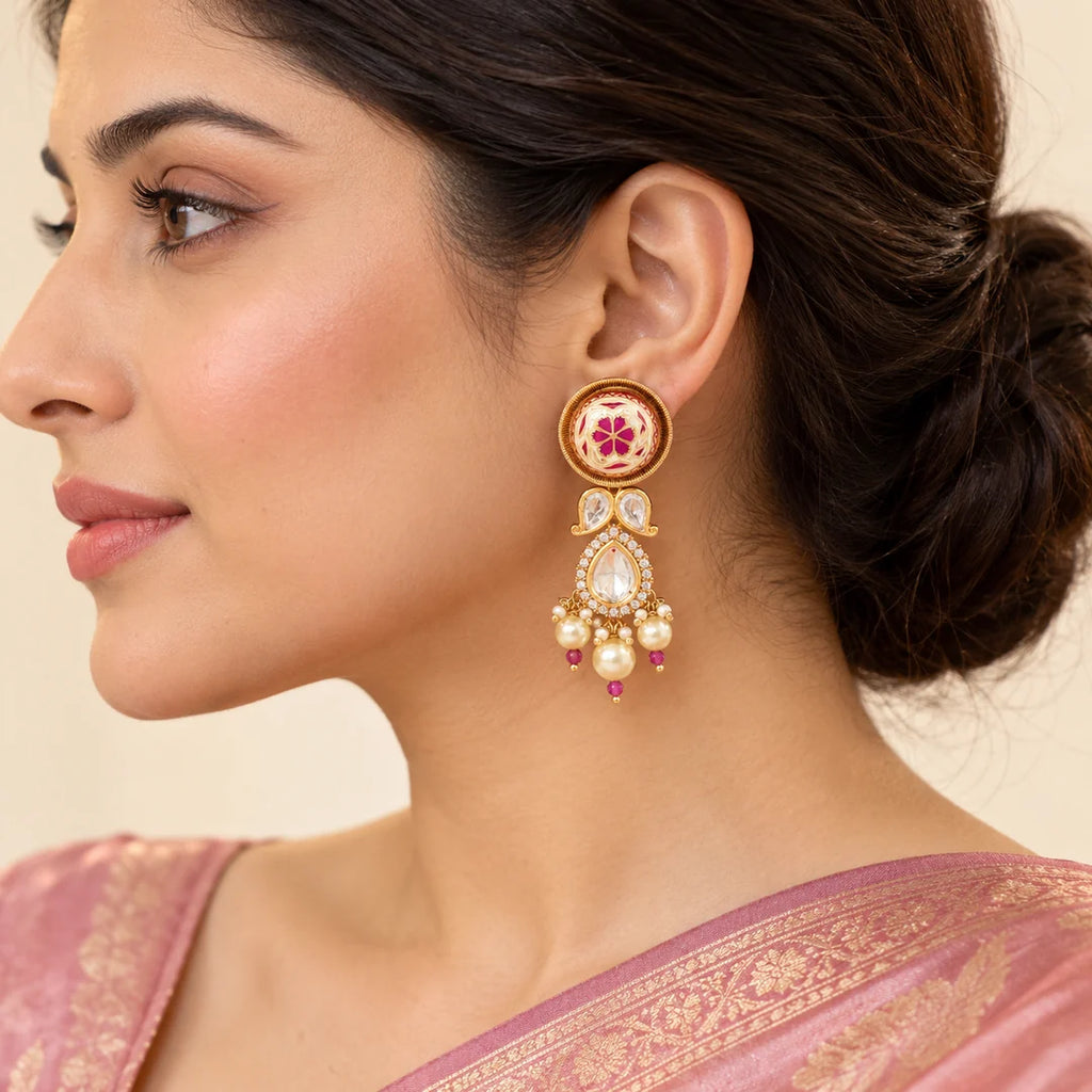 Side-profile model wearing a Mrinalini pink floral drop earring with clear stones and cream pearl-style beads.
